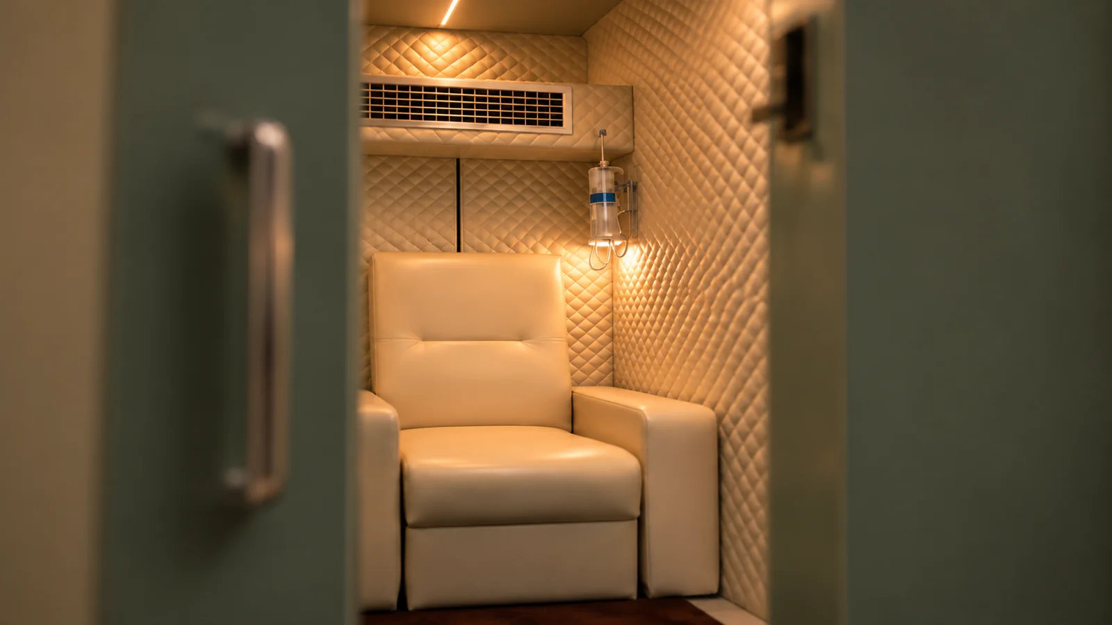 The quilted cream interior of the chamber with a reclining cream leather armchair